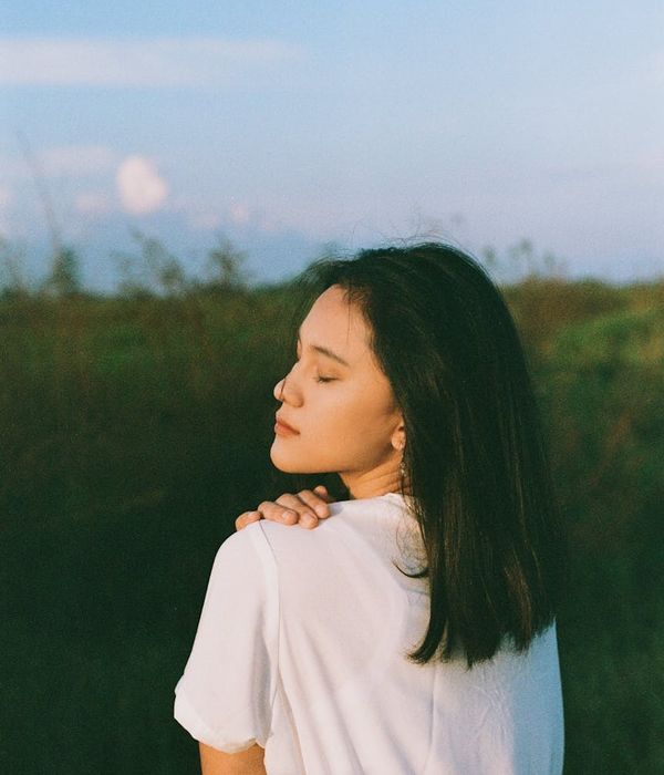 Woman practicing mindful breathing in a calm, dark environment with blue light.